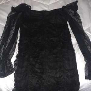 black dress with mesh sleeves a and ruffled body